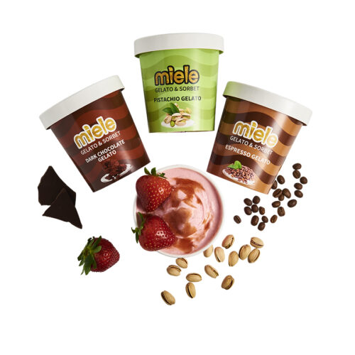 Dark chocolate, pistachio, strawberry, and espresso gelato pints surrounded by ingredient pieces
