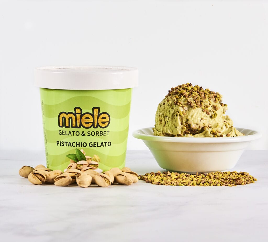 pint of miele pistachio gelato next to bowl of pistachio gelato