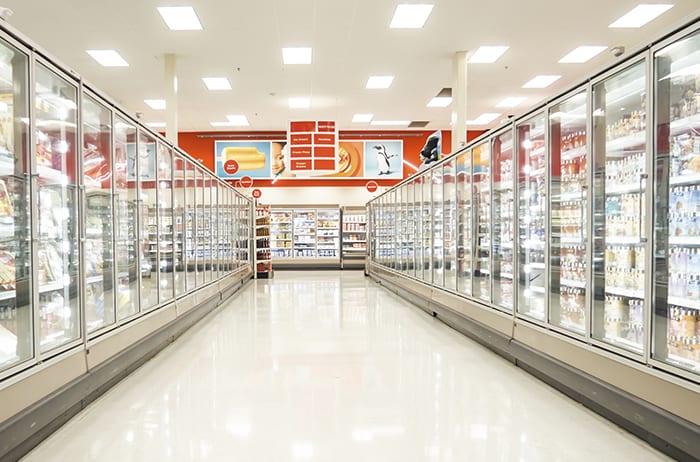 empty brightly lit grocery store freezer aisle